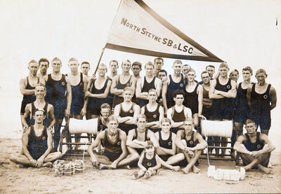 Members of North Steyne Surf Lifesaving Club then known as North Steyne Surf Bathers and Lifesaving Club, pictured on the beach with two reels