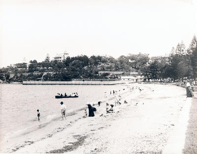 people on beach with pool and Gallery building in background