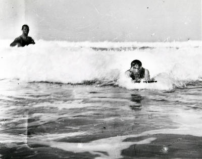 Man riding a surfboard in a prone position