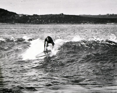 Man about to stand up on a surfboard