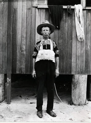 Elderly man, possibly Percy Jones, on Manly Beach, wearing an early rescue belt