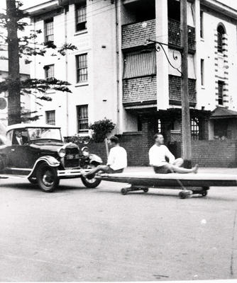 Taking the boards to Freshwater' in front of 'Cleveden Mansions' one man in car with board in back, two men on boards in from of the car.