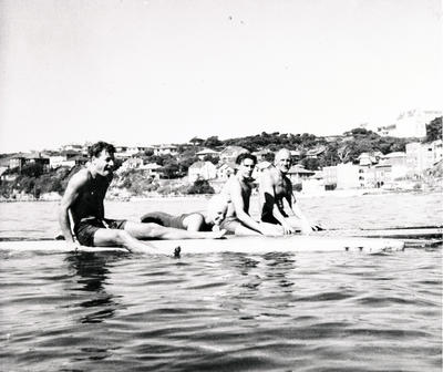 Assorted cuttings c.1941' 3 men sitting on longboards, one woman lying down.