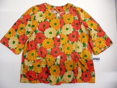 Beach coat, terry towelling, orange, yellow, white, red, green floral pattern. Two pockets on front, white pearl buttons.