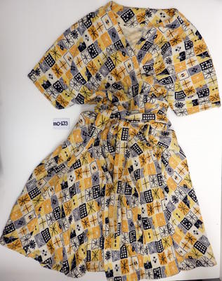 Cotton towelling yellow gold black grey stars in box pattern on white crossover bodice four gored flared skirt extended sleeve two side pockets machine sewn