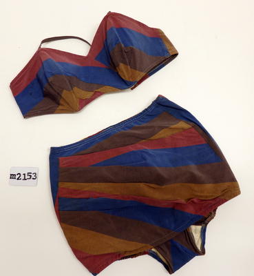 Striped rayon/rubber two piece with boned bra with halter straps & back fastening. Pants are draped from right side into modersty skirt and waist + legs are elasticised. Crutch is lined