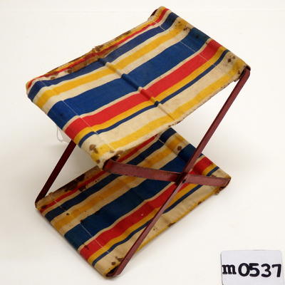 Headrest striped cotton top and base in yellow blue red and white red painted metal structure of criss cross lengths joined at centre