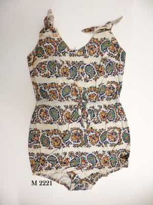 Cotton playsuit, white with yellow, green, blue, red, pink paisley design. Whites buttons down front, tie around waist, ties on shoulders straps.