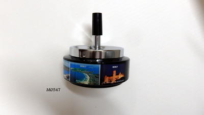 Ashtray, metal, base painted black with strip of labelled Manly photos around, hydrofoil, ferry terminal, aerial view Manly, St Patricks Seminary, Council Chambers etc. Unpainted plunger top - plastic