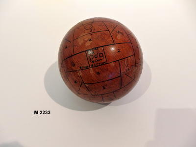 Wooden gas ball with black numbering and lettering inscribed over it.