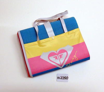 Fold out Roxy beach mat with carry handles, yellow, pink and blue with inflatable pillow attached. Roxy logo in white.