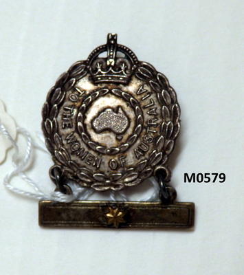 Metal badge and bar with centre star hanging by rings below relief front outer wreath with crown at top text 'to the women of Australia' inner wreath with map of Australia inside pin verso and numbers/ inscription