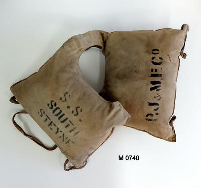 Life jacket South Steyne canvas dirty cream colour two padded square shaped sacks joined at shoulders black stamped printing on front inside back (see labels) four bias cords attached at bottom tied