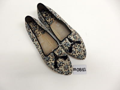 Blue black and white floral patterned cloth covered shoes grey cloth lined with black trim and black rubber sole covered on underside by yellow brown plastic sole size 7