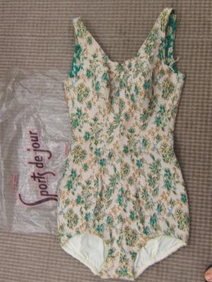 white one piece with all-over pattern of green leaves and gold thread