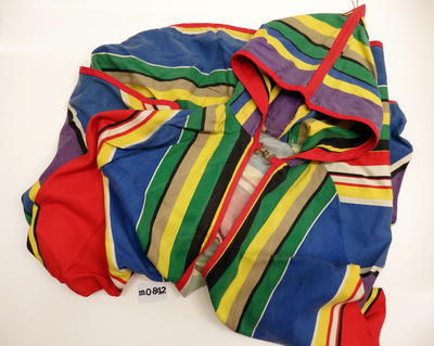 Multicoloured striped cloak with hood. Thick cotton with red braid trim, metal clasp at neck.