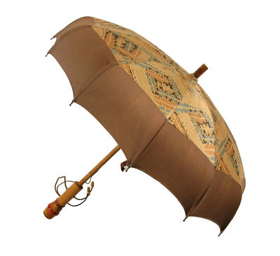 Parasol with wooden central rod, cotton canopy in blue and orange pattern on cream with brown band, metal frame decorated in red and orange, handle with leather rope, shallow dome shape with curved edge