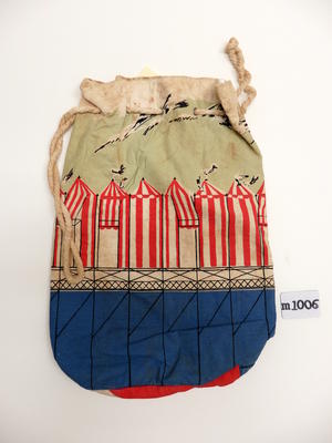 Cotton beach bag with red, white, green, blue beach tent motifs. White drawstring top