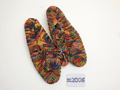 Multicoloured stretchable shoes with full cover, tie up with pom-poms. Leather soles.