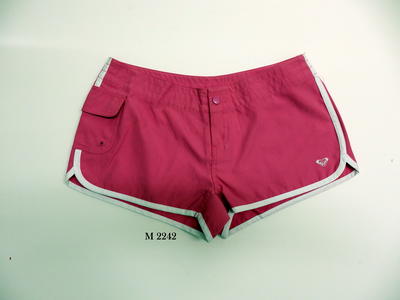 Roxy bright pink short boardshorts with white stripe along side of short and along the hem. White Roxy logo LHS. Pocket on RHS. Roxy printed in white across back. Pink metal zip and one silver press stud.