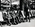 Group portrait of three soldiers, a civilian and a dog, on the promenade at Manly Beach