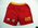 Long nylon board shorts in red with yellow waistband and printed "SURF RESCUE' on left leg - There is a hip pocket on each side + 'Kellogg's NUTRIGRAIN' + 'SURF LIFESAVING AUSTRALIA' on right leg. Unlined